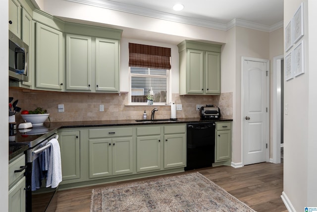 kitchen featuring appliances with stainless steel finishes, green cabinetry, tasteful backsplash, and a sink