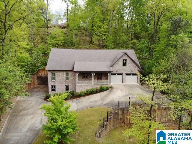 view of front of property with driveway, a garage, covered porch, and fence