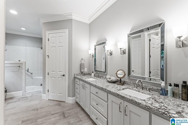 full bath featuring ornamental molding, a shower stall, double vanity, and a sink