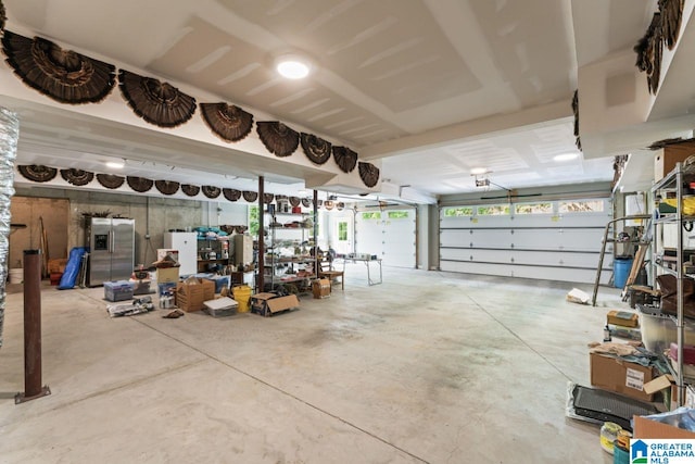 garage featuring stainless steel refrigerator with ice dispenser