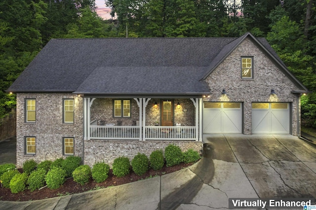 view of front of home featuring a porch, brick siding, a shingled roof, a garage, and concrete driveway