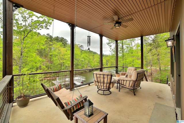 view of patio / terrace with an outdoor hangout area, a ceiling fan, and a view of trees