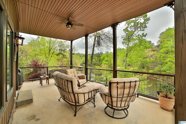 view of patio / terrace featuring outdoor lounge area, ceiling fan, and a view of trees