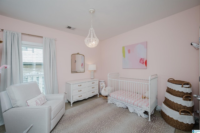 bedroom featuring carpet floors, visible vents, and a crib
