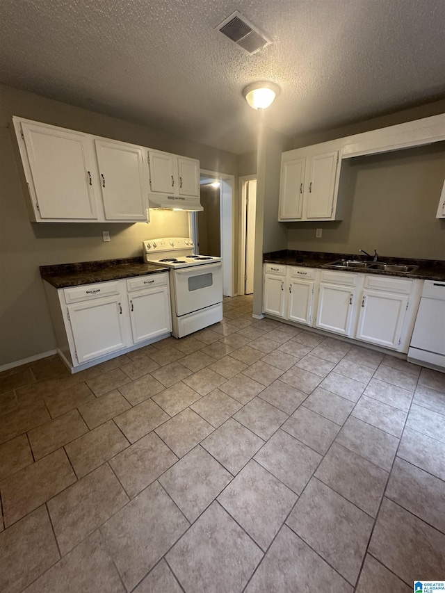 kitchen featuring visible vents, white appliances, a sink, and white cabinets
