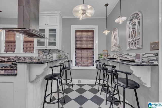 2910 W Meighan Blvd, Gadsden, AL 35904 - kitchen with backsplash, island exhaust hood, white cabinetry, and a breakfast bar area