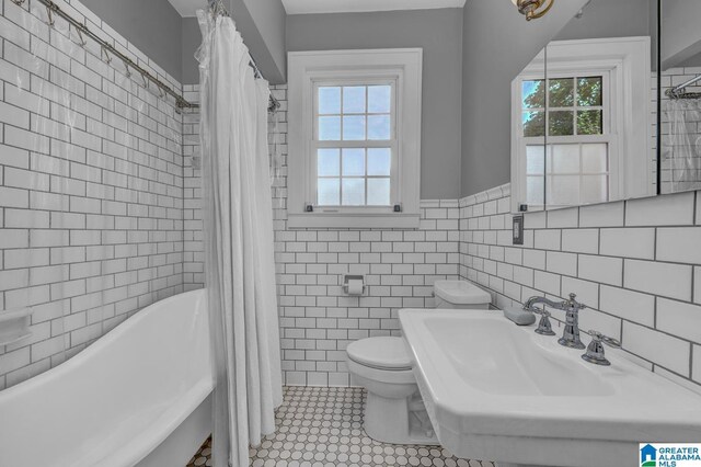 2910 W Meighan Blvd, Gadsden, AL 35904 - full bathroom featuring a washtub, a sink, tile walls, a wainscoted wall, and toilet