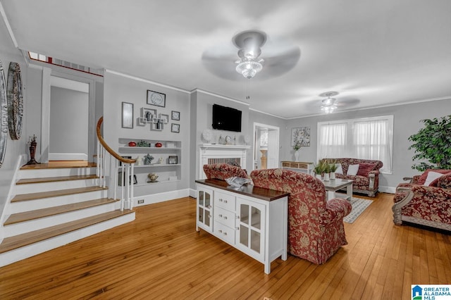 2910 W Meighan Blvd, Gadsden, AL 35904 - living area featuring light wood-style floors, stairs, ceiling fan, a fireplace, and ornamental molding