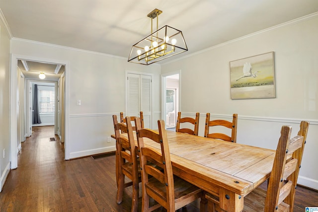dining space with baseboards, dark wood-style floors, ornamental molding, and attic access