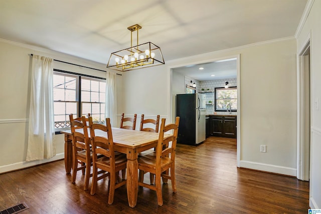 dining area with a notable chandelier, visible vents, ornamental molding, and dark wood-type flooring