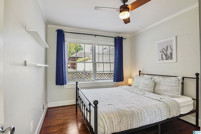 bedroom featuring a ceiling fan, visible vents, wood finished floors, baseboards, and ornamental molding