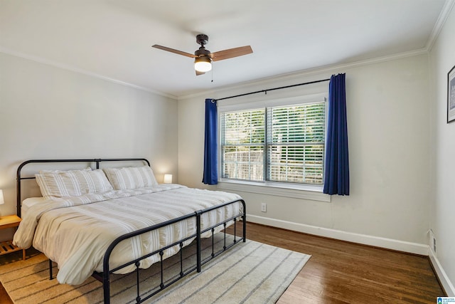 bedroom featuring baseboards, ornamental molding, a ceiling fan, and wood finished floors