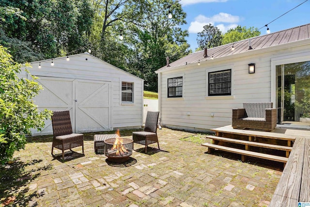 view of patio / terrace with a storage shed, a fire pit, and an outdoor structure