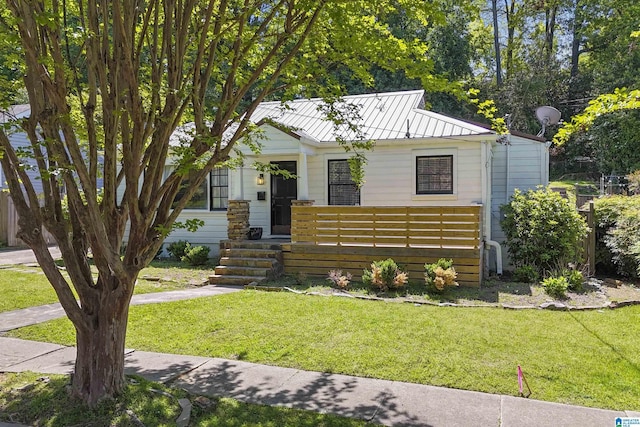 bungalow-style home with a front lawn, metal roof, and a standing seam roof