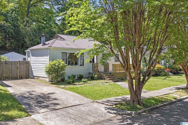 bungalow with fence, metal roof, and a front yard