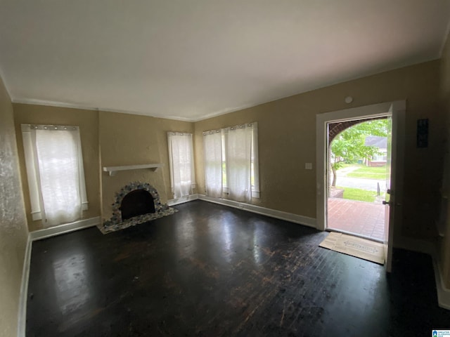 unfurnished living room featuring baseboards, dark wood-style floors, a fireplace, and crown molding