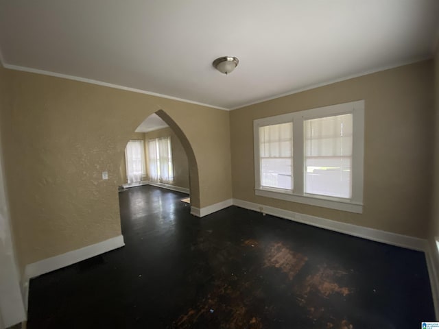 spare room with baseboards, arched walkways, dark wood finished floors, and crown molding
