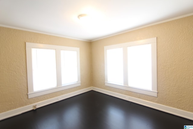 unfurnished room featuring a textured wall and crown molding