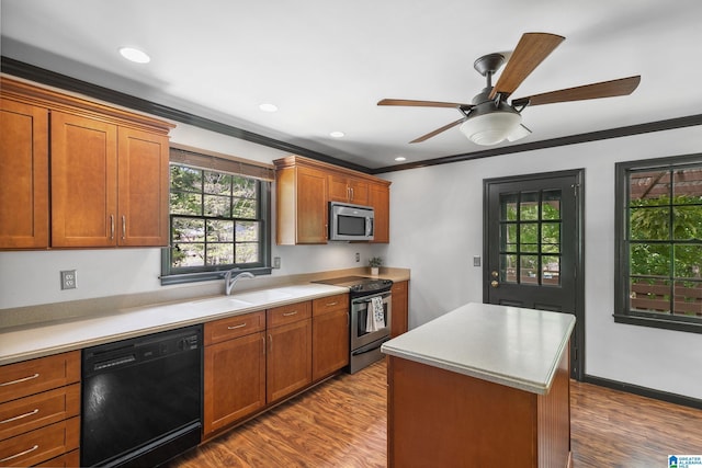 kitchen featuring ornamental molding, appliances with stainless steel finishes, a sink, and dark wood-type flooring
