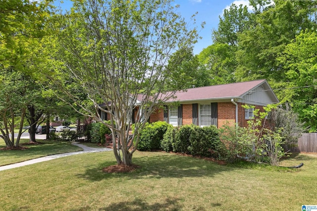 single story home with fence, brick siding, and a front yard