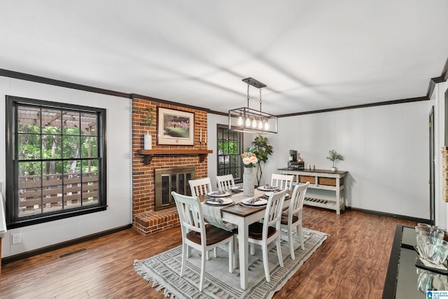 dining room featuring visible vents, wood finished floors, a healthy amount of sunlight, and crown molding