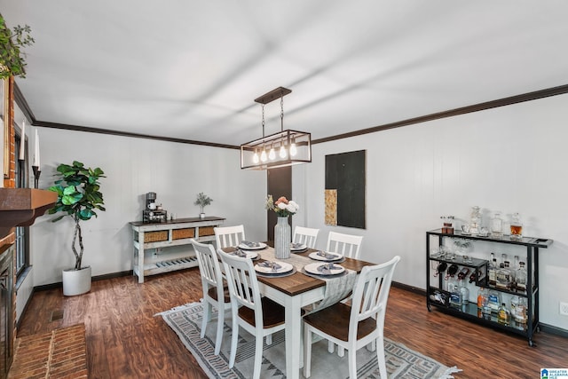 dining room with visible vents, baseboards, wood finished floors, and ornamental molding