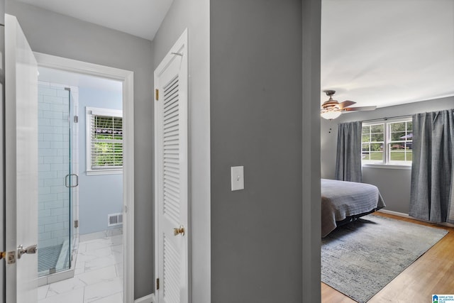 hall featuring visible vents and baseboards