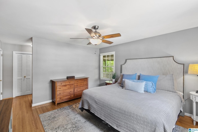 bedroom with ceiling fan, baseboards, and wood finished floors