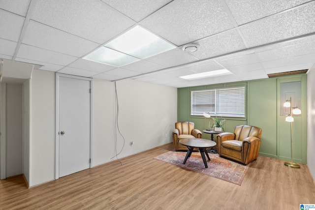 sitting room featuring wood finished floors and a paneled ceiling