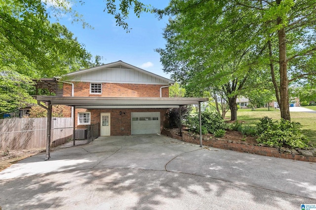 view of front of home with fence, an attached garage, board and batten siding, driveway, and brick siding
