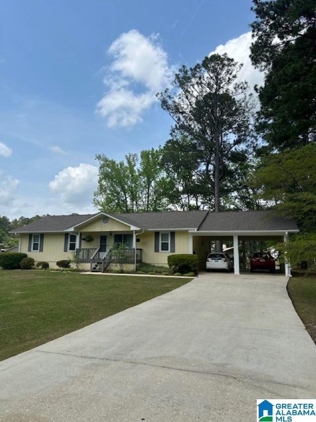 single story home featuring concrete driveway, a carport, a front yard, and covered porch