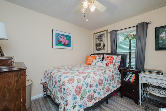 bedroom featuring baseboards, wood finished floors, and ceiling fan