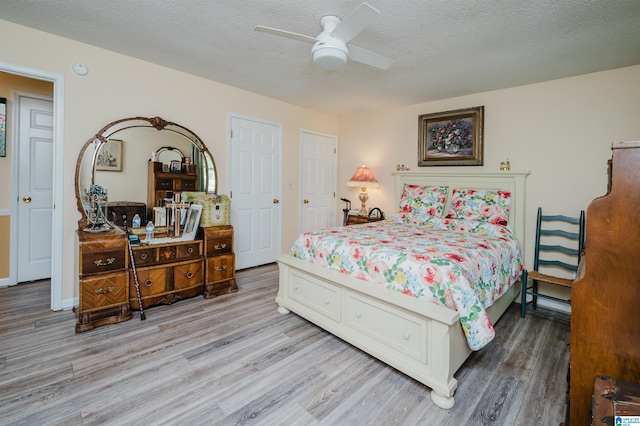 bedroom featuring a textured ceiling, wood finished floors, and a ceiling fan