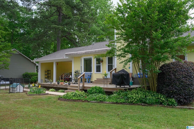 back of house with a deck, a yard, and fence