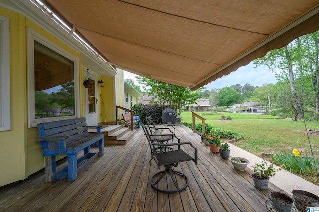 wooden terrace featuring a lawn