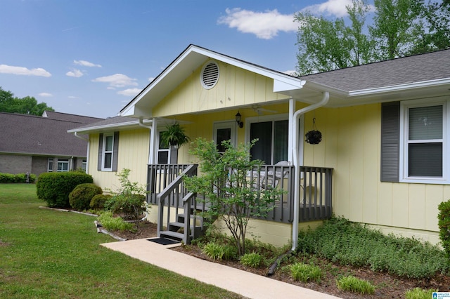 view of front of home with a front lawn, a shingled roof, and covered porch