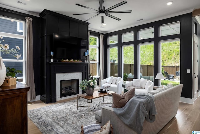 living area with crown molding, a large fireplace, and visible vents