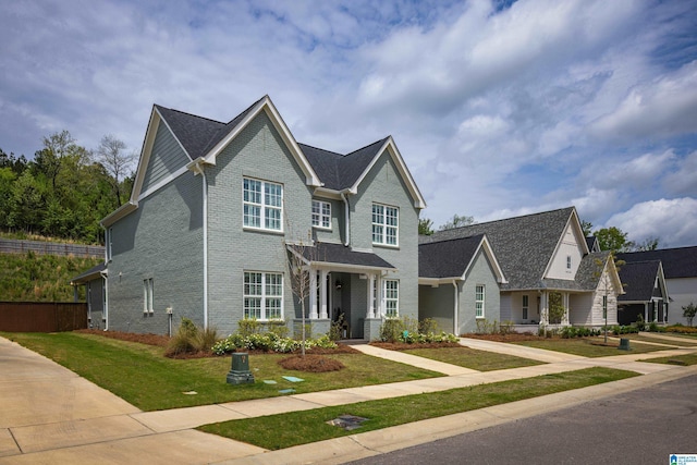 view of front of home featuring brick siding and a front yard