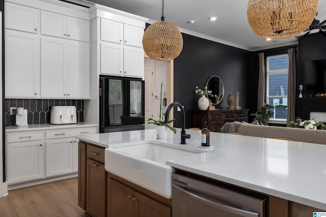 kitchen featuring decorative backsplash, dishwasher, a sink, light wood-type flooring, and crown molding