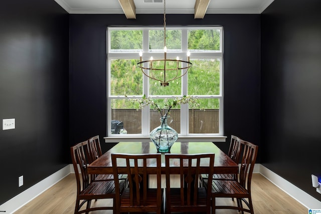dining area featuring an inviting chandelier, beam ceiling, a wealth of natural light, and light wood-style floors