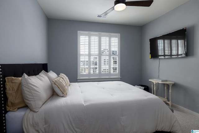 carpeted bedroom with a ceiling fan, visible vents, and baseboards