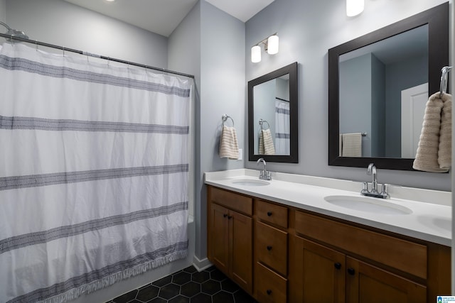 bathroom with tile patterned floors, a shower with shower curtain, double vanity, and a sink