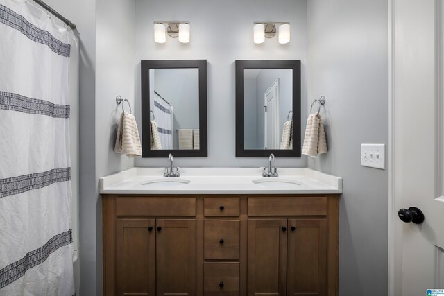 full bath with double vanity, curtained shower, and a sink