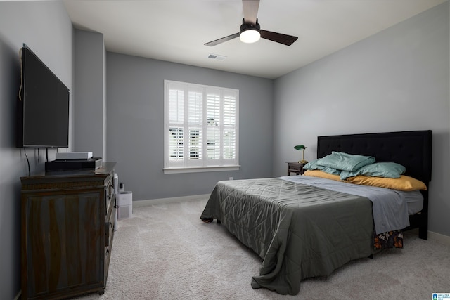 bedroom featuring baseboards, visible vents, a ceiling fan, and light colored carpet