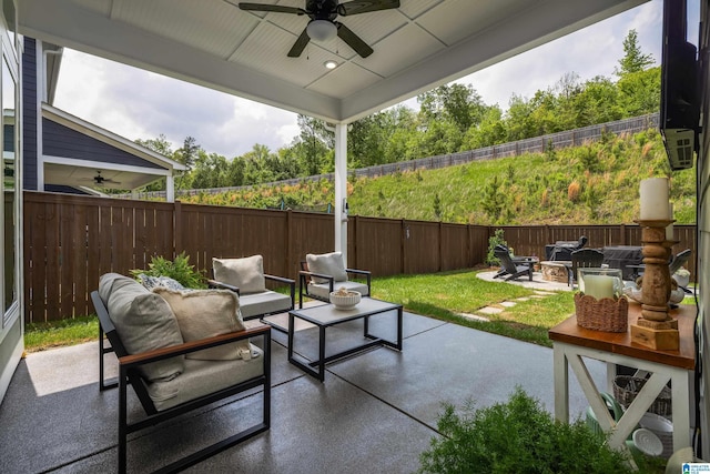 view of patio featuring an outdoor living space with a fire pit, ceiling fan, and a fenced backyard