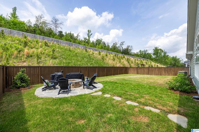 view of yard featuring a fire pit, a patio, and a fenced backyard