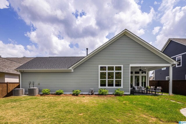 rear view of house with a lawn, ceiling fan, and a fenced backyard