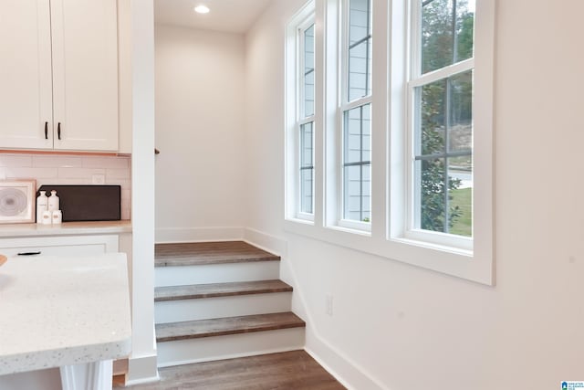 interior details with baseboards, wood finished floors, recessed lighting, and backsplash