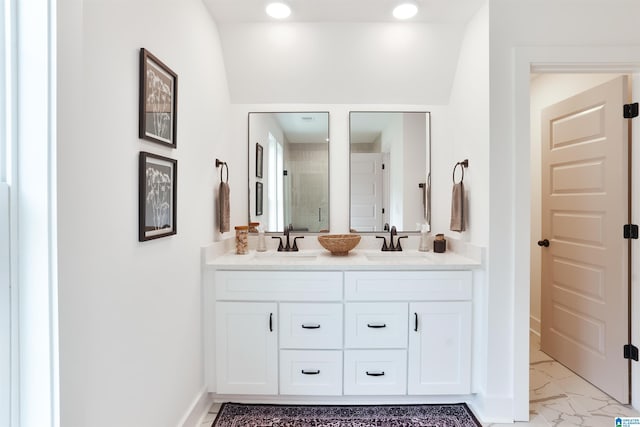 bathroom featuring a shower stall, marble finish floor, a sink, and double vanity