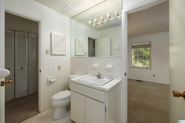 bathroom featuring tile walls, vanity, a closet, toilet, and tile patterned flooring